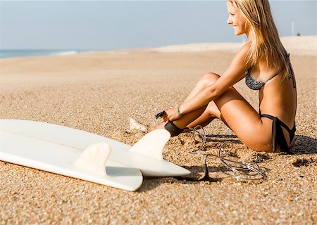 simsearch:400-08432413,k - Beautiful surfer girl getting ready to surf and putting the leash Stock Photo - Budget Royalty-Free & Subscription, Code: 400-08506188