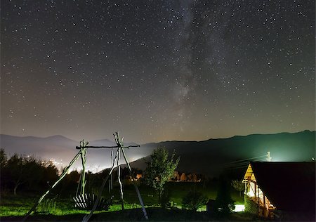 Milky Way in starry night sky and rural yard illuminated in green color on mountain hill. Photographie de stock - Aubaine LD & Abonnement, Code: 400-08506319