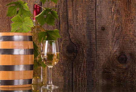 simsearch:400-08110621,k - Glass of wine with barrel white bottle behind grapeleaves and dark wooden background Stock Photo - Budget Royalty-Free & Subscription, Code: 400-08506801