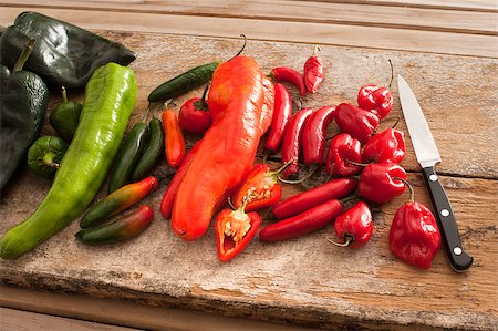 stockarch (artist) - Assortment of colorful fresh red and green spicy chili peppers on an old rustic wooden table with a kitchen knife Foto de stock - Royalty-Free Super Valor e Assinatura, Número: 400-08507187