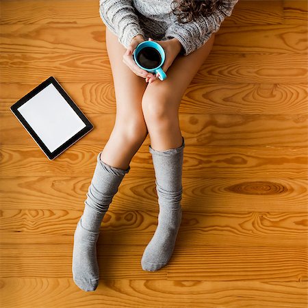 socks and floor and leg - Woman sitting on the floor drinking a coffee Stock Photo - Budget Royalty-Free & Subscription, Code: 400-08507379