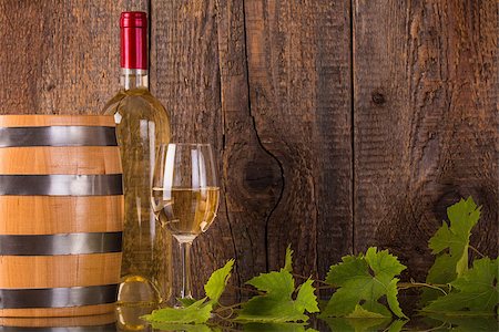 simsearch:400-08110621,k - Glass of wine with white bottle barrel grapeleaves and dark wooden background Stock Photo - Budget Royalty-Free & Subscription, Code: 400-08507801