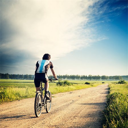 Cyclist Riding a Bike on the Country Road. Rear View. Summer Nature Background. Healthy Lifestyle Concept. Instagram Styled Toned and Filtered Photo. Copy Space. Foto de stock - Super Valor sin royalties y Suscripción, Código: 400-08500129