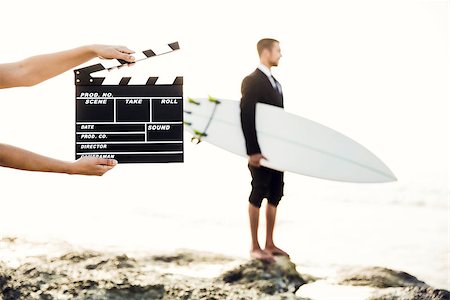 surfers men model - Businessman in front of a clapboard holding is surfboard. Concept about a man starting a new life. Stock Photo - Budget Royalty-Free & Subscription, Code: 400-08500578