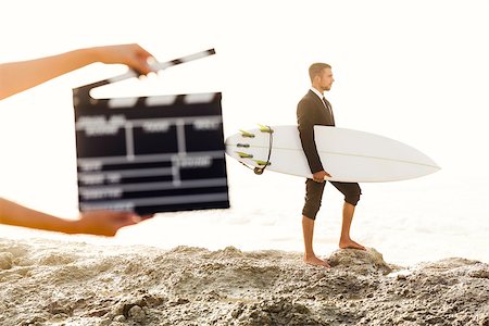 surfers men model - Businessman in front of a clapboard holding is surfboard. Concept about a man starting a new life. Stock Photo - Budget Royalty-Free & Subscription, Code: 400-08500579