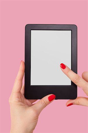 simsearch:400-08501429,k - Female hand holding e reader isolated on pink background. Reading, education and learning concept. Photographie de stock - Aubaine LD & Abonnement, Code: 400-08501429