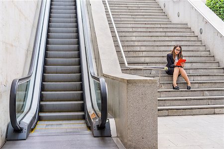 View of office woman sitting in the stairs with tablet and glasses near scalator Stock Photo - Budget Royalty-Free & Subscription, Code: 400-08529451