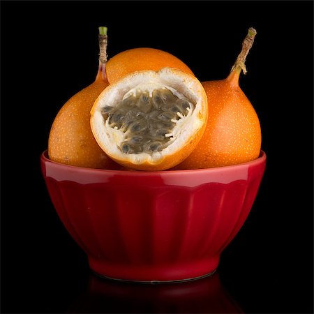 simsearch:400-08500819,k - Passion fruit maracuja granadilla on ceramic red bowl, black background. Stock Photo - Budget Royalty-Free & Subscription, Code: 400-08530528