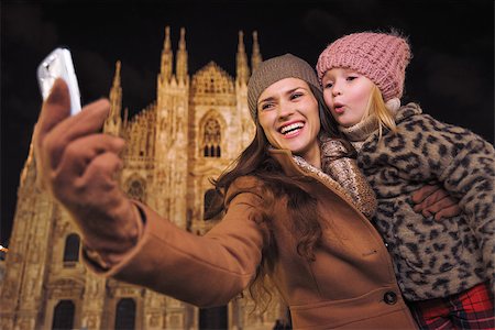 simsearch:400-08341864,k - Family holidays in style. Happy mother and daughter taking selfie with smartphone in the front of Duomo in Milan, Italy in the evening Fotografie stock - Microstock e Abbonamento, Codice: 400-08530930