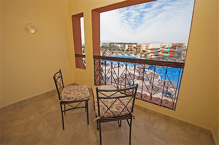 simsearch:649-08562431,k - Balcony with chairs and table overlooking swimming pool at luxury tropical hotel resort Stock Photo - Budget Royalty-Free & Subscription, Code: 400-08531479