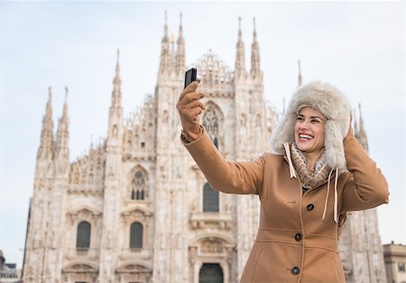 simsearch:400-08530001,k - Discovering Italian treasures hidden in Milan. Smiling woman taking selfies with digital camera in the front of Duomo while sightseeing Milan Stockbilder - Microstock & Abonnement, Bildnummer: 400-08532356