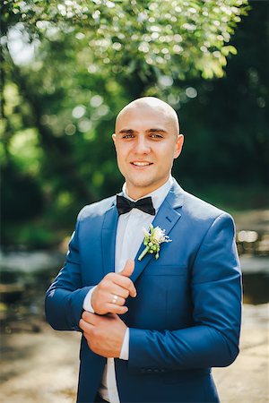 simsearch:400-04171391,k - Groom in a blue suit buttoning cuffs in park Stock Photo - Budget Royalty-Free & Subscription, Code: 400-08532400