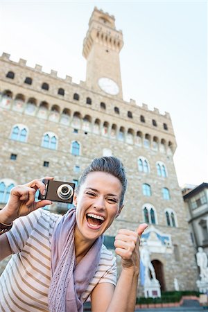 simsearch:400-08530001,k - It's time to tick off must-see Florence treasures of a bucket list. Smiling young woman tourist with digital photo camera showing thumbs up in the front of Palazzo Vecchio in Florence, Italy Stockbilder - Microstock & Abonnement, Bildnummer: 400-08532479