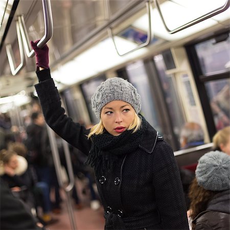 Beautiful blonde caucasian lady wearing winter coat traveling by metro in rush hour. Public transport. Foto de stock - Royalty-Free Super Valor e Assinatura, Número: 400-08532579