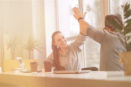 simsearch:400-04651437,k - Toned Happy smiling freelance man and woman doing high-five in office. Business people or students working in library with laptop computers. Stockbilder - Microstock & Abonnement, Bildnummer: 400-08533324