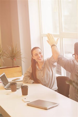 simsearch:400-04651437,k - Toned Happy freelance man and woman being students studying in library or office interior. Smiling business people using laptop and drinking coffee. Stockbilder - Microstock & Abonnement, Bildnummer: 400-08533325