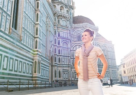 simsearch:400-08530001,k - An amble around awe-inspiring Duomo in Florence, Italy. Smiling young woman tourist standing in the front of Duomo and looking into the distance Stockbilder - Microstock & Abonnement, Bildnummer: 400-08533558
