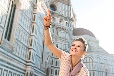 simsearch:400-08415527,k - An amble around awe-inspiring Duomo in Florence, Italy. Smiling woman tourist pointing on something while standing in the front of Duomo Stock Photo - Budget Royalty-Free & Subscription, Code: 400-08533560