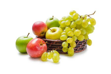 Various fresh ripe apples and grapes placed in a wicker basket and around isolated on a white background Stock Photo - Budget Royalty-Free & Subscription, Code: 400-08554097