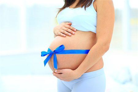 simsearch:400-04205919,k - woman holds her baby bump, tied with a blue bow Stock Photo - Budget Royalty-Free & Subscription, Code: 400-08550759
