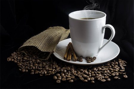 simsearch:659-08904383,k - Coffee cup with coffee beans surrounding saucer with burlap bag. Fotografie stock - Microstock e Abbonamento, Codice: 400-08551203