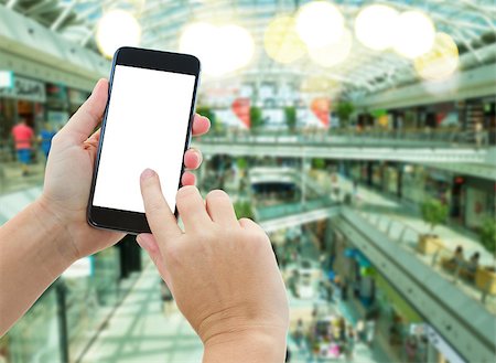 smartphone payment - someones  hands holding mobile smart phone with empty screen  on comercial center blur background business concept Foto de stock - Super Valor sin royalties y Suscripción, Código: 400-08551478