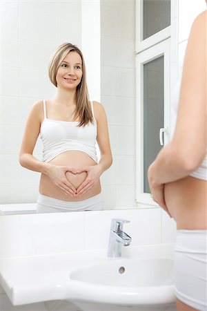 simsearch:400-07892376,k - Pregnant woman in looking into bathroom mirror Foto de stock - Royalty-Free Super Valor e Assinatura, Número: 400-08553111