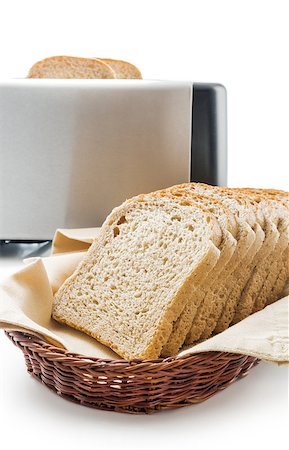 Wholemeal toast bread slices placed on a cotton cloth napkin in a wicker basket close up arranged with electric toaster isolated on white background. Stock Photo - Budget Royalty-Free & Subscription, Code: 400-08553568