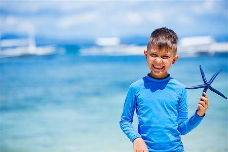 photos beach boys in asia - Boy holding a blue starfish on sandy beach, Philippines Stock Photo - Budget Royalty-Free & Subscription, Code: 400-08574465