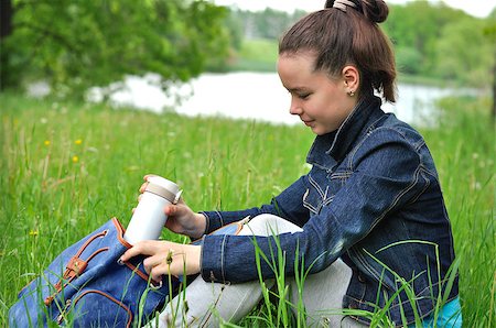 Girl sitting at a picnic on the grass near the pond Stockbilder - Microstock & Abonnement, Bildnummer: 400-08575562