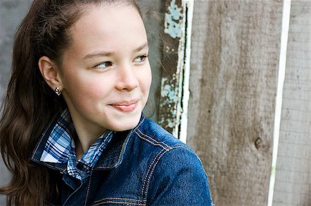 Girl turns and smiles sitting on a background of old door Stockbilder - Microstock & Abonnement, Bildnummer: 400-08575946