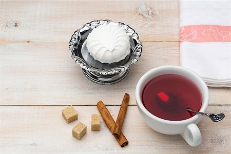 simsearch:659-03533716,k - Cup of red tea. Cane sugar and cinnamon sticks with sweet dessert on wooden table Stock Photo - Budget Royalty-Free & Subscription, Code: 400-08573232