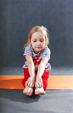 little girl doing gymnastic exercises for stretching on a yoga mat. Stretching during training children's fitness. Yoga for children Stock Photo - Budget Royalty-Free & Subscription, Code: 400-08573622