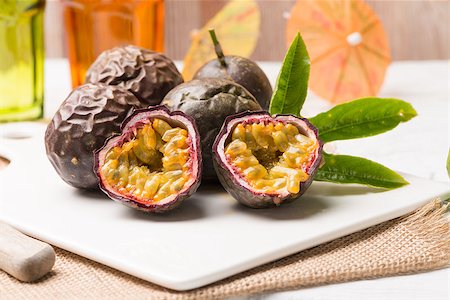 passiflora - Passion fruits on white ceramic tray on wooden table background. Photographie de stock - Aubaine LD & Abonnement, Code: 400-08617504