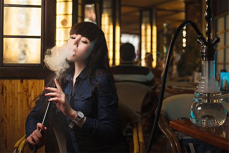 pipe smoking women images - Concept: leisure lifestyle. Beautiful young woman with hookah in a bar restaurant Stock Photo - Budget Royalty-Free & Subscription, Code: 400-08617808