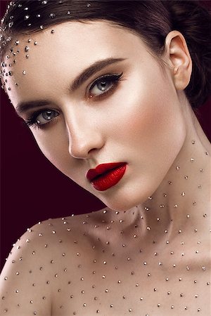 Portrait of a beautiful girl with a bright make-up, red lips and crystals on the body. The beauty of the face. Photos shot in the studio. Photographie de stock - Aubaine LD & Abonnement, Code: 400-08619016