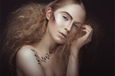 Beautiful girl with a pattern on the body in the form of birds, creative makeup and hairstyle lush. Beauty face. Picture taken in the studio on a gray background. Photographie de stock - Aubaine LD & Abonnement, Code: 400-08619017