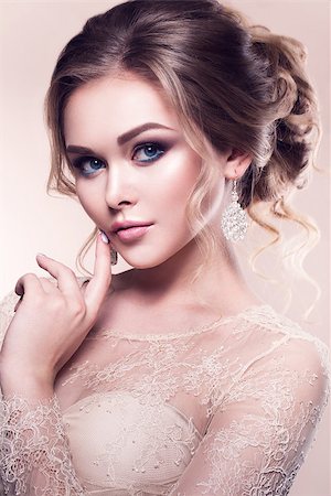simsearch:400-05208182,k - Beautiful bride with fashion wedding hairstyle - on beige background.Closeup portrait of young gorgeous bride. Wedding. Studio shot. Foto de stock - Royalty-Free Super Valor e Assinatura, Número: 400-08625054