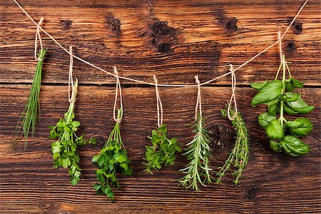 Culinary herbs. Aromatic herbs, basil, coriander, parsley, chive, mint and rosemary hanging on string on old country style wooden background. Stock Photo - Budget Royalty-Free & Subscription, Code: 400-08626599