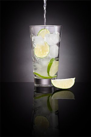 Pouring water into a glass full with ice cubes and lime slices. Healthy water drinking. Drinking regime. Stock Photo - Budget Royalty-Free & Subscription, Code: 400-08628729