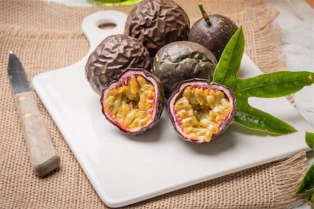 passiflora - Passion fruits on white ceramic tray on wooden table background. Photographie de stock - Aubaine LD & Abonnement, Code: 400-08620364
