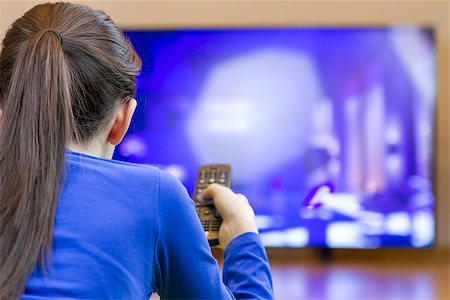Teenager girl with remote control watching tv on cartoons. Foto de stock - Super Valor sin royalties y Suscripción, Código: 400-08621214