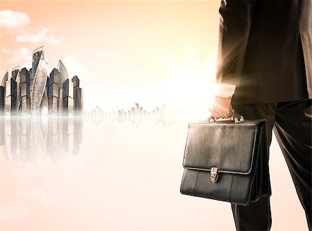 Businessman with suitcase against modern city, rear view Stock Photo - Budget Royalty-Free & Subscription, Code: 400-08622097