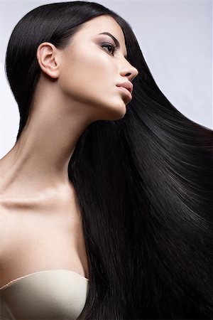 Beautiful brunette girl in move with a perfectly smooth hair, and classic make-up. Beauty face. Picture taken in the studio on a white background. Photographie de stock - Aubaine LD & Abonnement, Code: 400-08623142