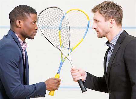 Two serious businessmen in suits standing face to face and holding rackets before having match in squash on court. Stock Photo - Budget Royalty-Free & Subscription, Code: 400-08646248