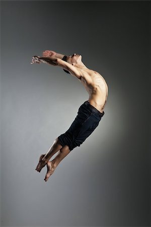 Caucasian man gymnastic leap posture on grey background Photographie de stock - Aubaine LD & Abonnement, Code: 400-08668615