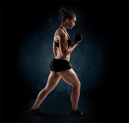 simsearch:400-08505882,k - Muscular woman with dumbbell on dark background Stock Photo - Budget Royalty-Free & Subscription, Code: 400-08668830