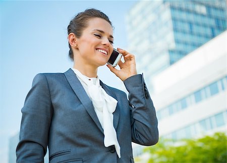 simsearch:400-06642775,k - Into the ultra-modern business trends. Smiling business woman in modern office district talking mobile phone Photographie de stock - Aubaine LD & Abonnement, Code: 400-08669022