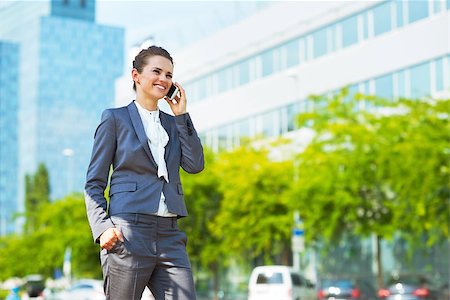 Into the ultra-modern business trends. Happy business woman in modern office district talking cellphone Photographie de stock - Aubaine LD & Abonnement, Code: 400-08669032