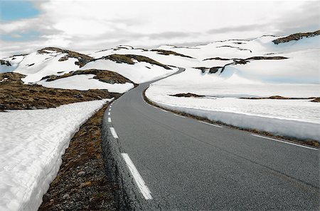 A narrow road winds through a snowy mountain pass in southwest Norway. Fotografie stock - Microstock e Abbonamento, Codice: 400-08669298